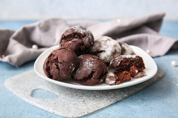 Plate of chocolate brownie cookies on blue background