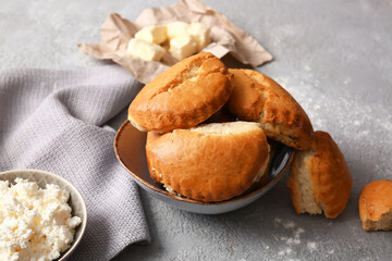 Bowl of tasty sochniki with cottage cheese on grey background