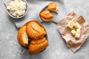 Bowl of tasty sochniki with cottage cheese and ingredients on grey background