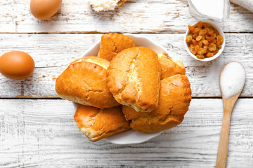 Bowl of tasty sochniki with cottage cheese on white wooden background