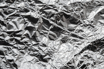 Texture of used crumpled aluminium food foil background. Shiny aluminum foil wrap without chocolate...