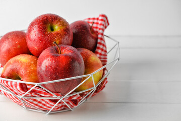 Basket with fresh apples on table