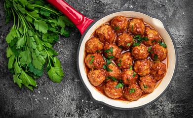 Homemade meatballs with tomato sauce and spices served in pan on black background. banner, menu, recipe place for text, top view