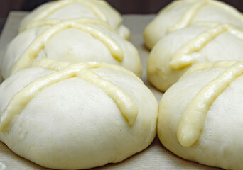 Raw unbaked scones. Ready to bake homemade traditional Easter buns with hot cross. Easter holiday baked goods. Close-up.