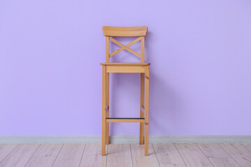 Wooden chair near violet wall