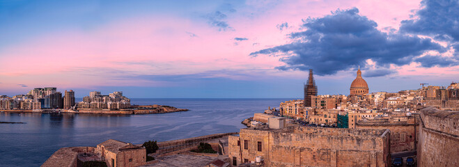Panoramic view of sunset over Valletta old town and harbor, Valletta, Malta.