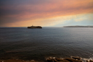 sunset over the sea with lighthouse