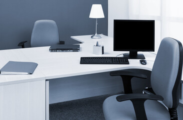 laptop and computer on desk in a modern office