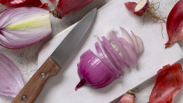 Chopped fresh tropea red onion on a wooden board close up, concept of cooking at home in the kitchen