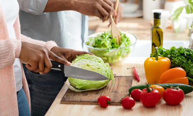 Healthy Nutrition. Black Man And Woman Cooking Fresh Vegetable Salad In Kitchen, Closeup