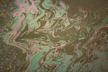 Gasoline on the asphalt. The texture of the fuel spilled on the road.