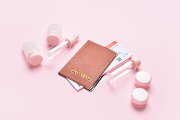 Empty travel cosmetics bottles, jars, passport and ticket on pink background