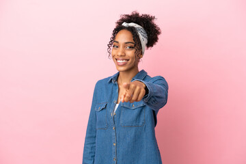 Young latin woman isolated on pink background pointing front with happy expression