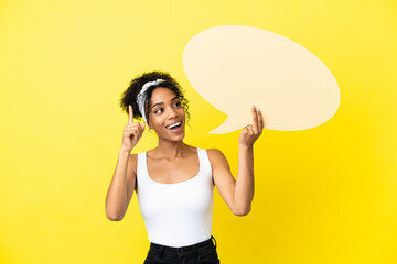 Young african american woman isolated on yellow background holding an empty speech bubble and...