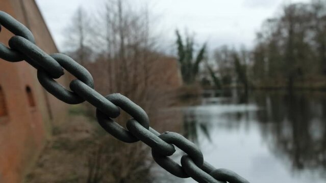 A large steel chain holds a drop gate over a moat. The camera moves along the chain. At the beautiful Spandau Zitadelle in Berlin. - Nine - High bitrate footage