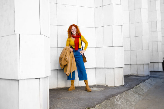 Curly readhead woman standing and smiling