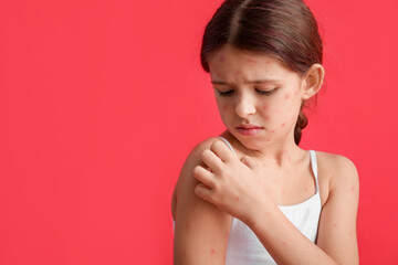Little girl ill with chickenpox on red background