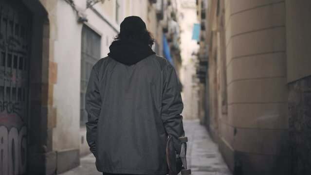 Man walking down an alleyway in Barcelona, Spain, slow motion medium shot following