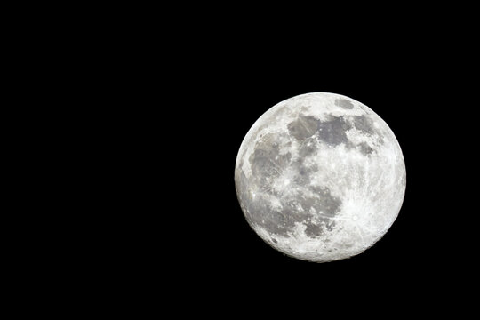 Full moon close-up on the right side of the picture on a black background
