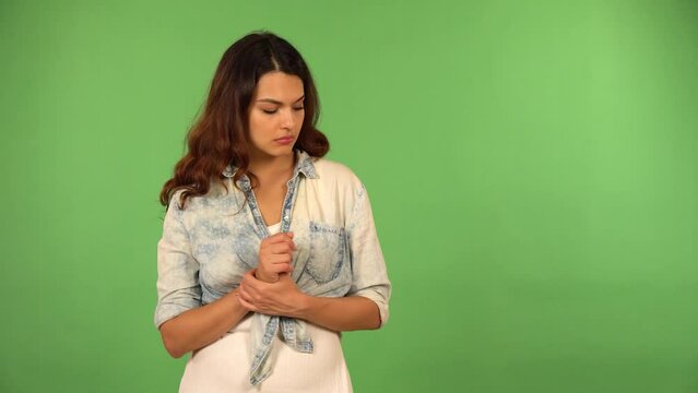 A young beautiful Caucasian woman thinks about something - green screen background