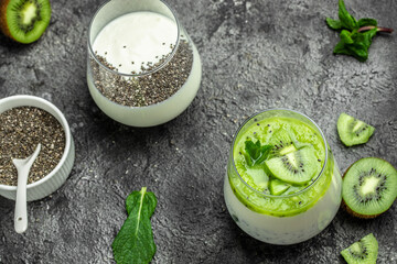 Healthy breakfast chia pudding with kiwi in glass jars on dark table. Clean eating, dieting, vegan...