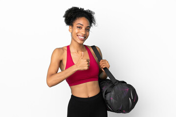 Fototapeta na wymiar Young sport african american woman with sport bag isolated on blue background giving a thumbs up gesture