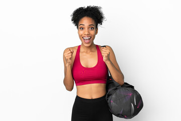 Fototapeta na wymiar Young sport african american woman with sport bag isolated on blue background celebrating a victory in winner position