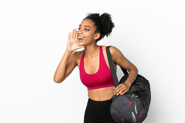 Young sport african american woman with sport bag isolated on blue background shouting with mouth wide open to the side