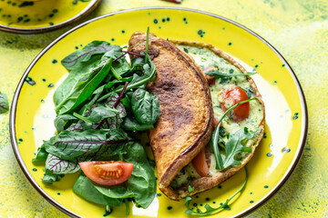 Frittata with fresh vegetables and cheese. Italian omelet and spinach salad on a yellow plate. Ketogenic, keto food. banner, menu recipe top view