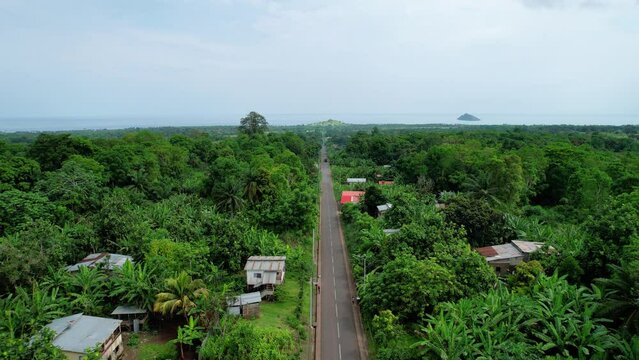 Aerial view flying along a road, in Sao Tome, west Africa - reverse, drone shot
