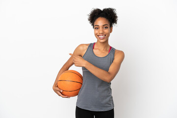 Young basketball player latin woman isolated on white background playing basketball and pointing to the lateral