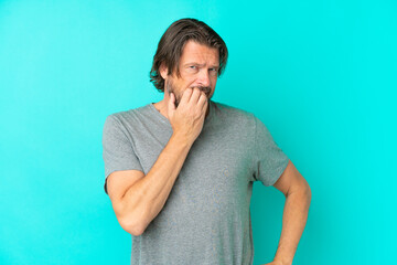 Senior dutch man isolated on blue background having doubts
