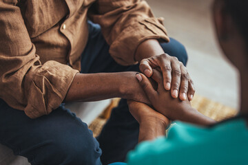 Closeup of a support hands. Closeup shot of a young woman holding a senior man's hands in comfort. Female carer holding hands of senior man - obrazy, fototapety, plakaty