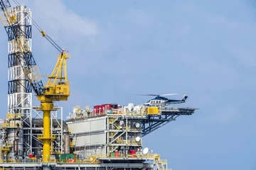 Fotobehang A helicopter landed on an oil production platform for transferring of offshore crew at oil field © wanfahmy