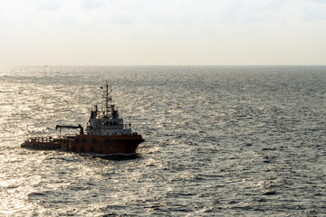 An anchor handling tug boat sailing at an offshore oil field