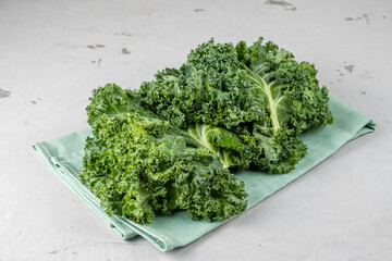 Fresh greens. Super food. Kale kale on a towel on a gray background.