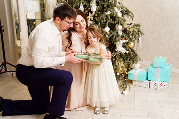 happy family with box of gift by Christmas tree. tradition giving gifts