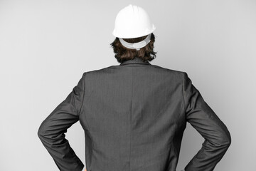 Young architect man with helmet over isolated background in back position