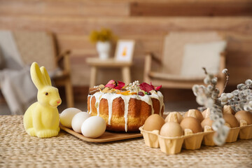 Easter cake, holder with eggs, rabbit and pussy willow branches on table