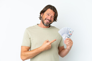 Senior dutch man taking a lot of money isolated on white background pointing back