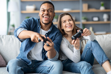 Domestic Entertainment. Joyful young multicultural couple playing video games in living room