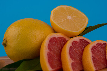 In the photo, sliced fruits, a knife and a cutting board: oranges, tangerines, lemon, lime, grapefruit. The composition of fresh citrus fruits. Sliced fresh citrus fruits on a chopping board. Close-up