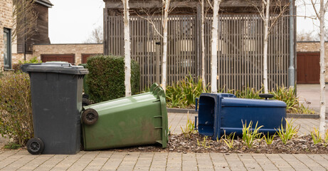 Waste and recycling bins blown over by excessive winds during a storm