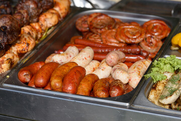 Roasted sausages with twigs and garlic in cast iron pan