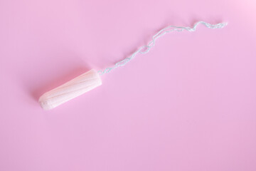 female tampon on a pink background. Hygienic white tampon for women.