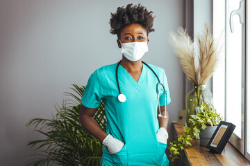 Portrait of an African American nurse wearing a protective face mask to avoid the transfer of germs...
