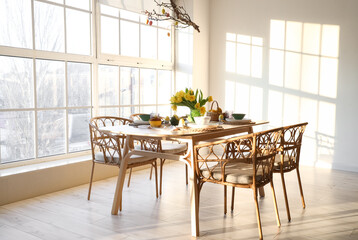 Dining table served for Easter celebration in light room interior