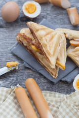Pressed and toasted double panini with ham and cheese served on sandwich paper on a wooden table,egg,Hot dog. This can be used as a business card background and can be used as an advertising image.