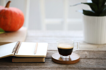 Coffee glass cup and notebooks and pumpkin