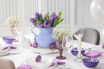 Stylish table setting with beautiful flowers and Easter eggs
